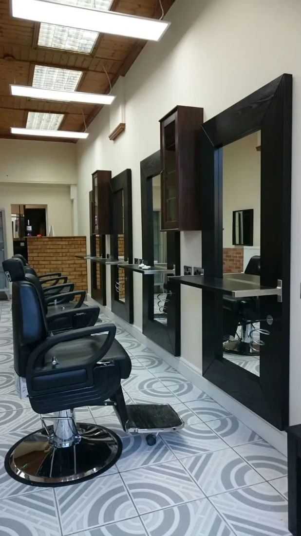 Inside Andy's Barber Shop — the row of chairs, black-framed mirrors and patterned floor