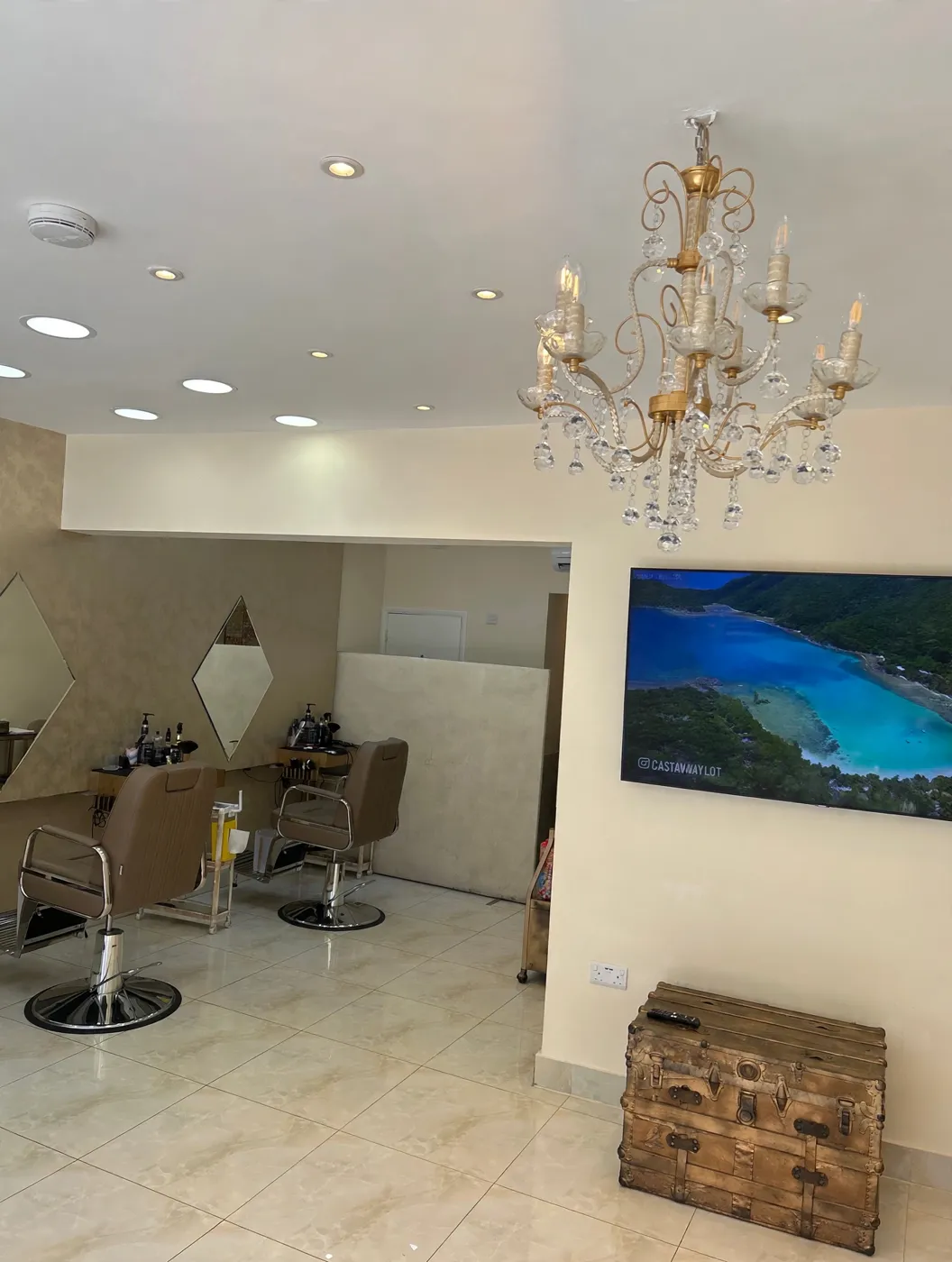 Inside Barber Ali — crystal chandelier, diamond mirrors and taupe barber chairs