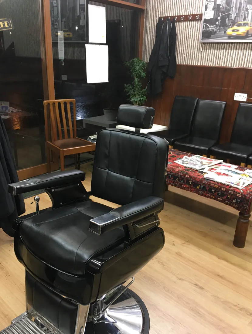 Inside Bohemian — the barber chair, waiting seats and rug-covered magazine table
