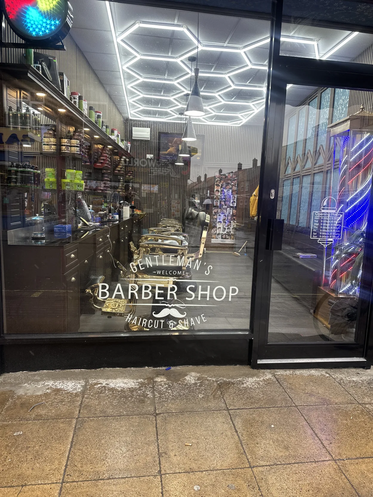Gentleman Barbers' glass frontage on Rye Lane: the Welcome Barber Shop window lettering, gold chairs and hexagon ceiling lights inside