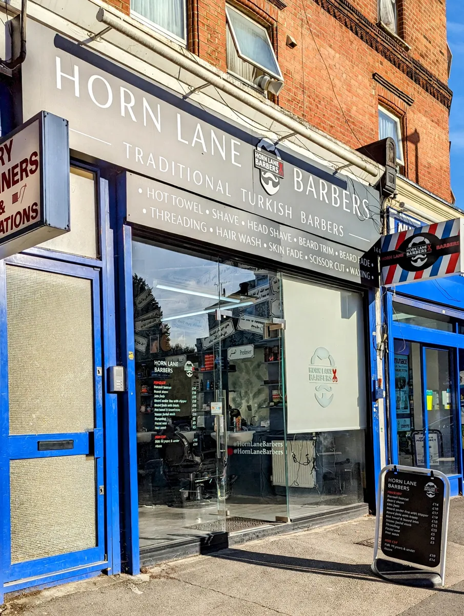 Horn Lane Barbers shopfront with its A-frame price board