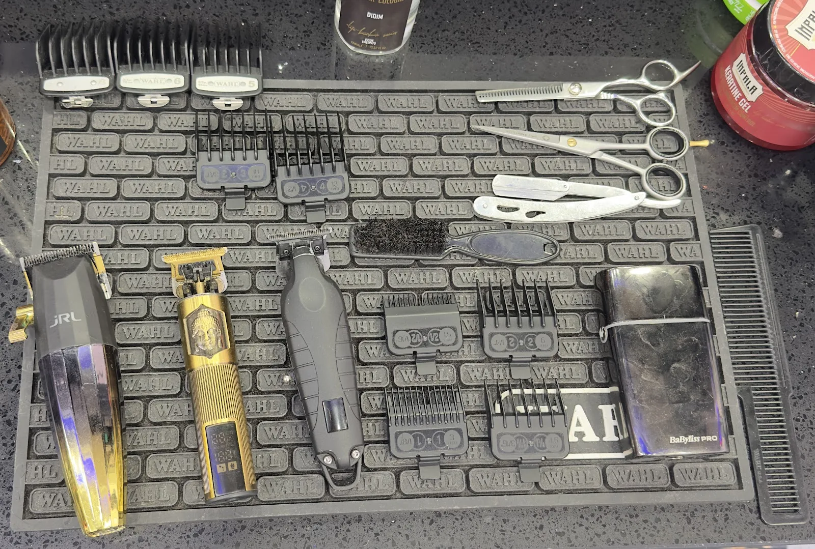 A barber's tools laid out on a WAHL mat at Mr Adam's: clippers, scissors, cut-throat razor and combs
