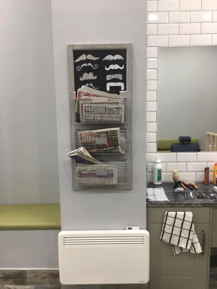 Inside Peter & Minos: a mirror, the moustache-art magazine rack and the tools counter