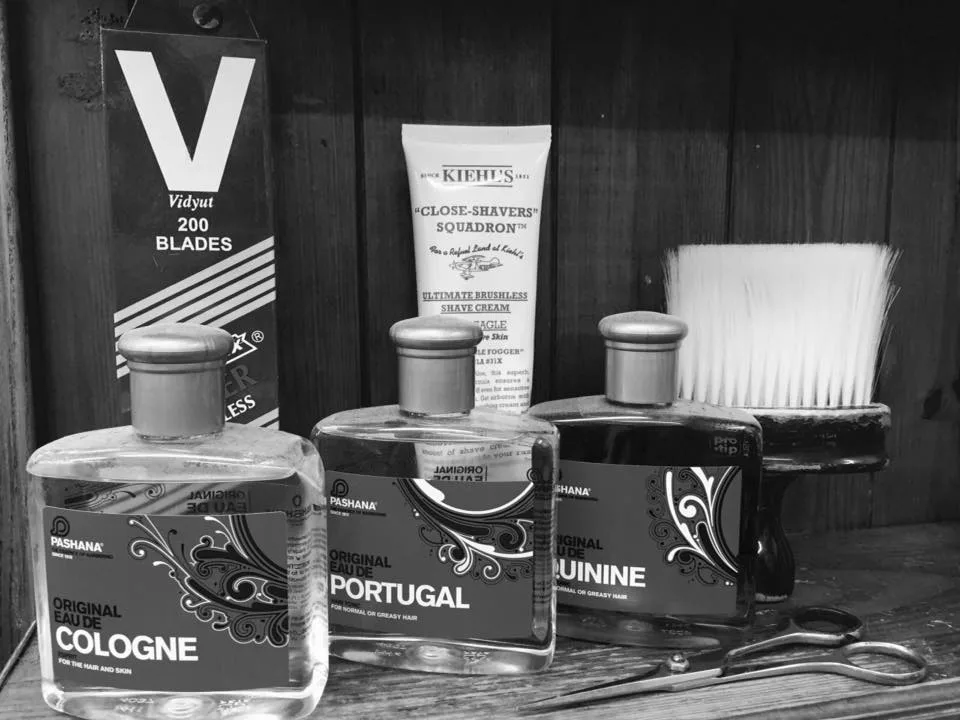 Traditional barbering stock at Peter & Minos: Pashana cologne, Eau de Portugal, quinine hair tonic, brush and scissors, in black and white
