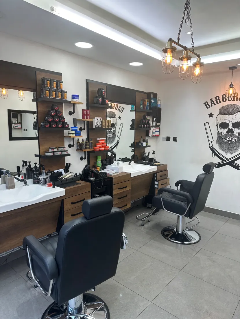 Inside Rama Barber Shop — walnut stations and the skull mural