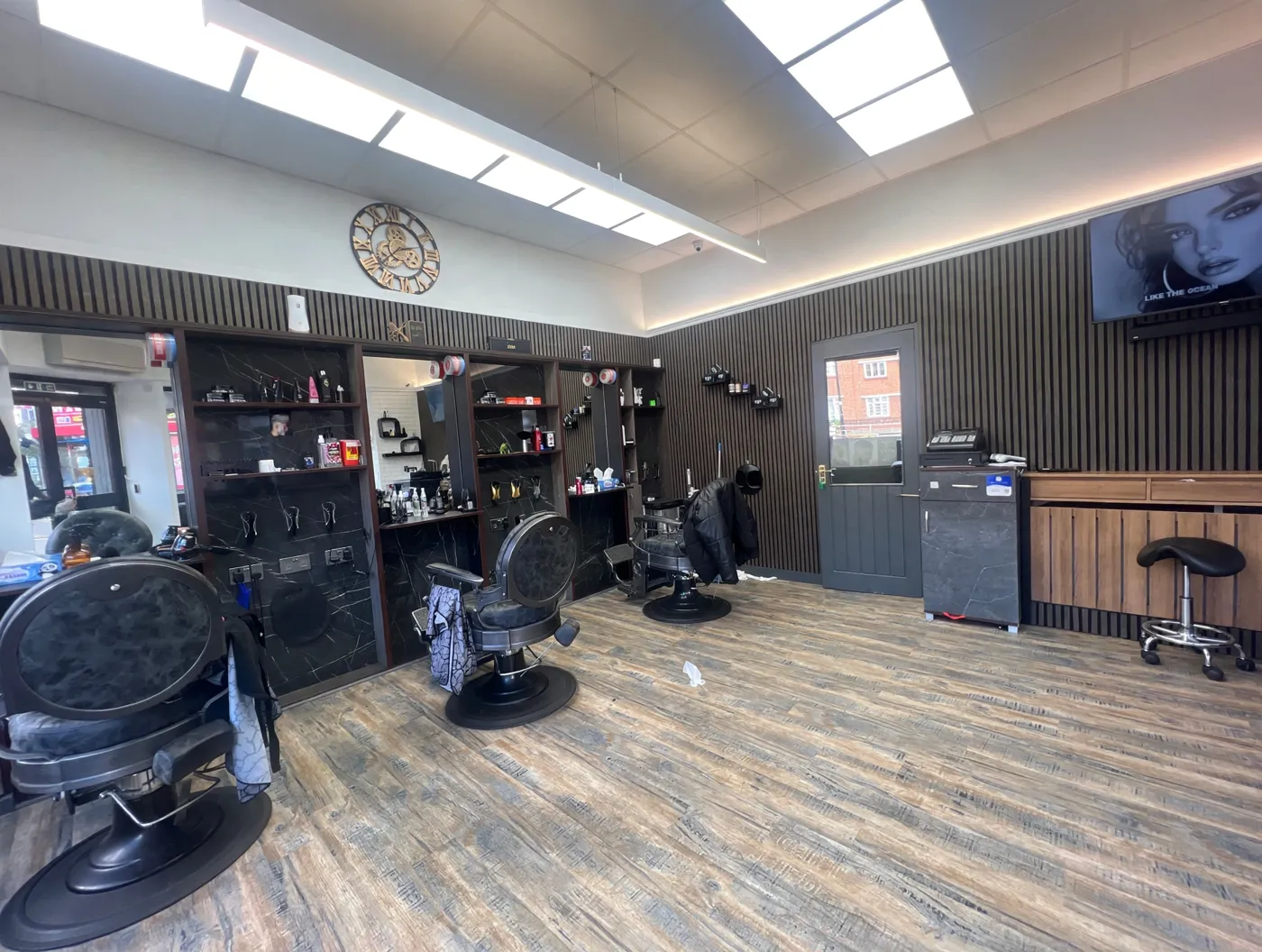 Inside ROYAL CUT 2 — slatted walls, marble shelving and the gear clock