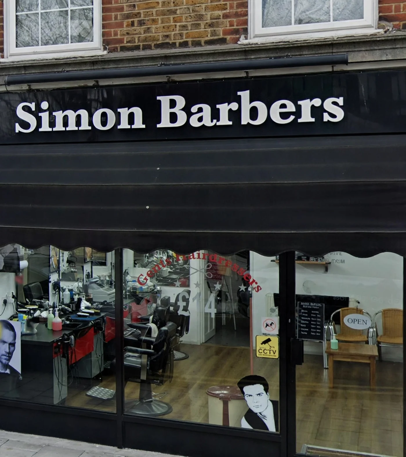 The Simon Barbers shopfront on New King Street — black fascia with white lettering, glass frontage showing the chairs inside
