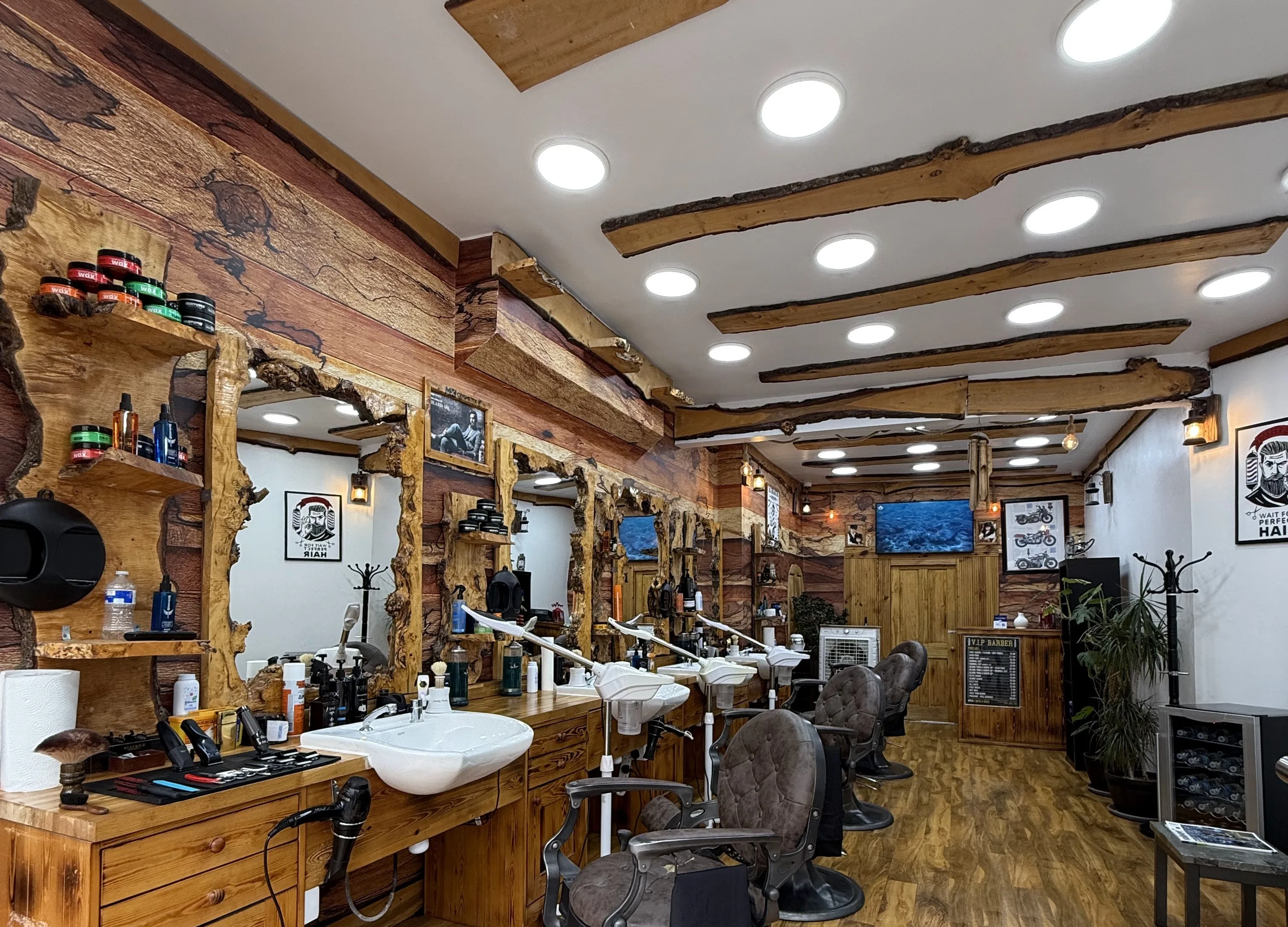 Inside VIP Barber: live-edge timber walls and ceiling beams, burled-wood mirrors, vintage barber chairs, sinks and a drinks fridge